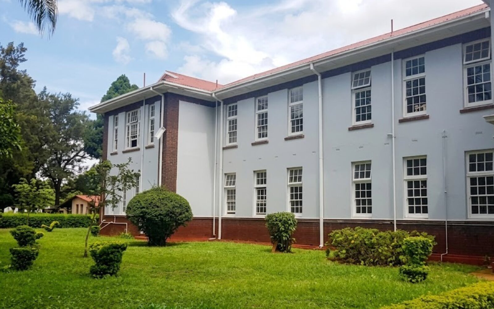 Two storeys of classrooms above the lawn.